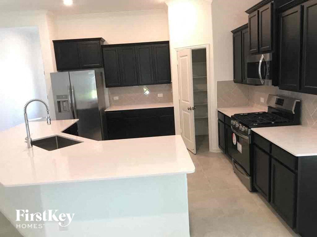 a kitchen with black cabinets and a white counter top