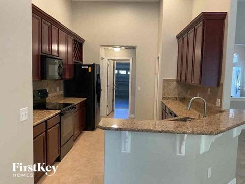 A kitchen with brown cabinets and a granite countertop.