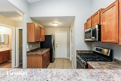 a kitchen with wooden cabinets and a stove and a microwave