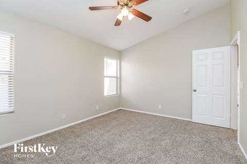 a bedroom with carpet and a ceiling fan