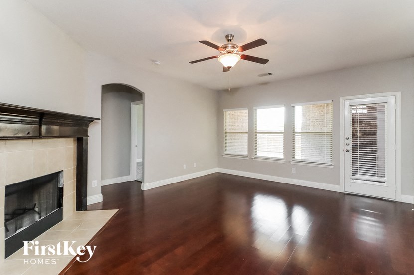 A spacious room with a fireplace and a ceiling fan.