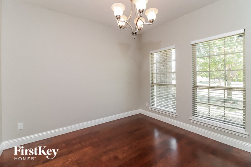 A room with wooden floors and a chandelier.