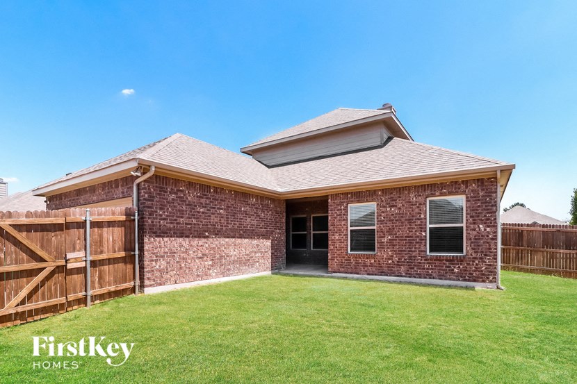 A brick house with a wooden fence in front of it.