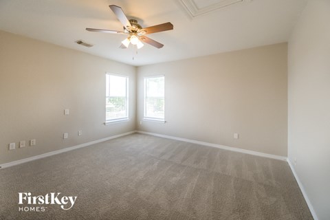 a living room with carpet and a ceiling fan