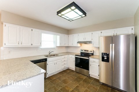 a white kitchen with stainless steel appliances and white cabinets