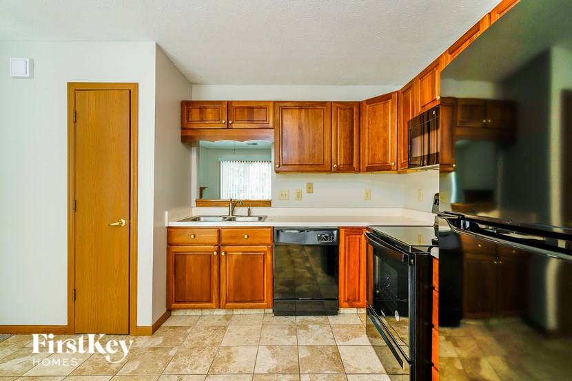 A kitchen with wooden cabinets and black appliances.