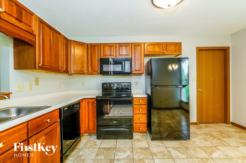 A kitchen with wooden cabinets and black appliances.