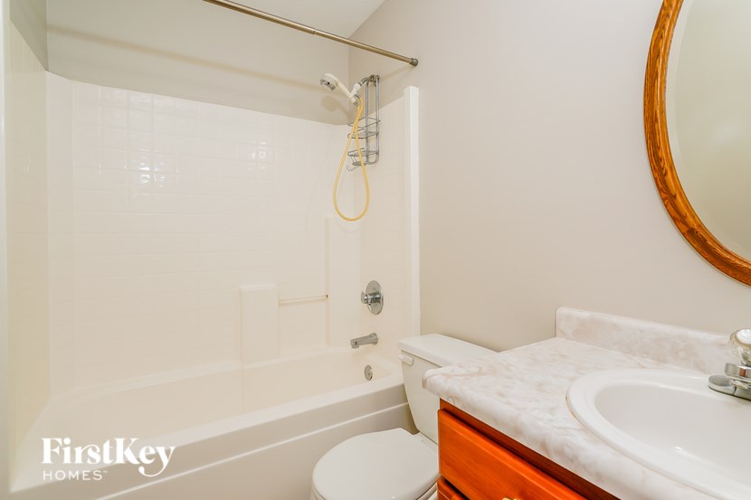 A bathroom with a white tub, sink, and toilet.