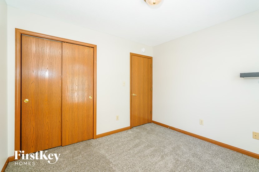 A room with two doors and a carpeted floor.