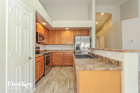 A kitchen with wooden cabinets and granite countertops.