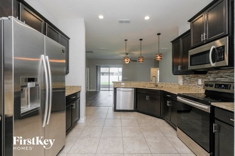 A kitchen with a refrigerator that says FirstKey Homes.