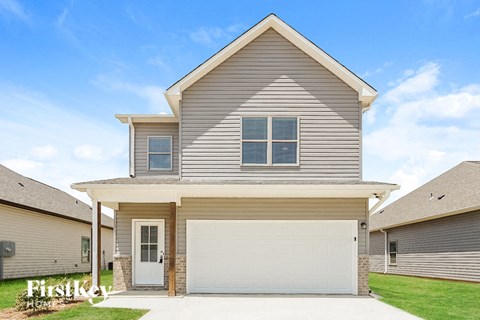a tan house with a white garage door