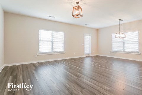 an empty living room with wood flooring and a lamp