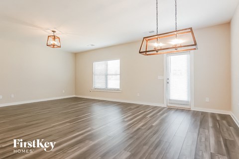 an empty living room with wood floors and two lamps