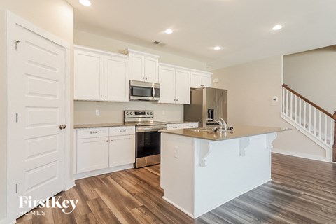 a kitchen with an island and a stove and a microwave