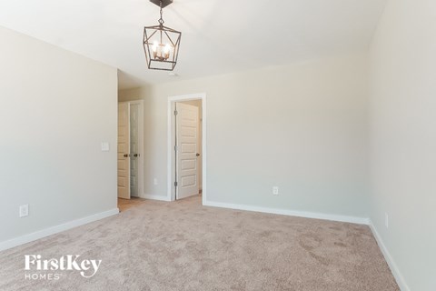 a empty living room with a light fixture and a closet
