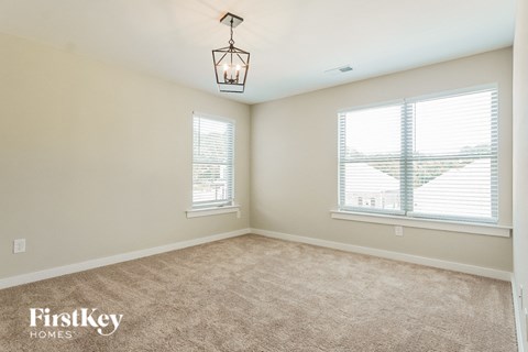 an empty room with two windows and a lamp