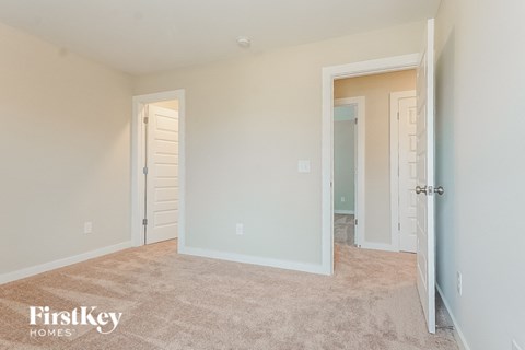 a bedroom with a closet and a door to a bathroom
