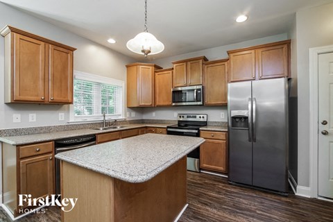 A kitchen with wooden cabinets and a granite countertop.