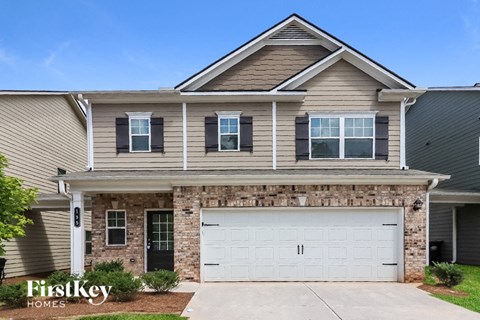 A two-story house with a garage is for sale.