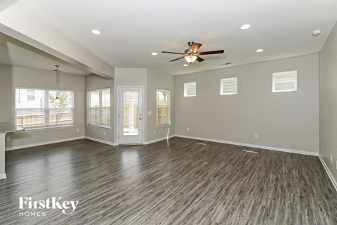 A spacious room with wood flooring and a ceiling fan.