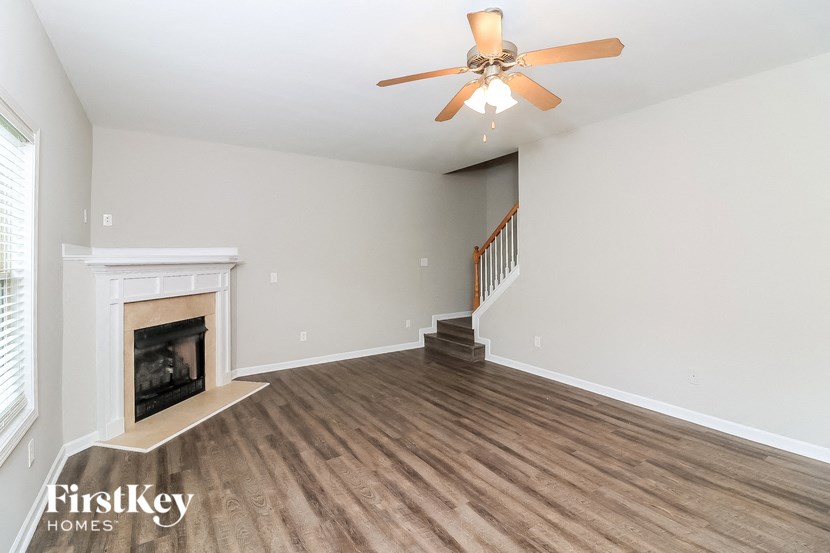 a living room with a fireplace and a ceiling fan