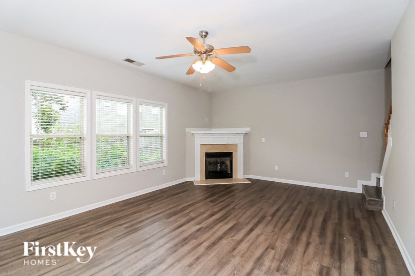 a living room with a ceiling fan and a fireplace