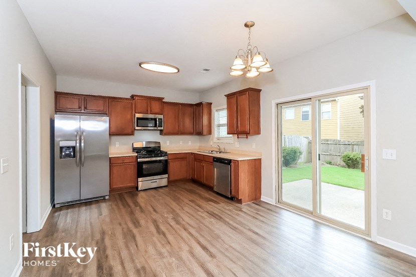 an empty kitchen with wood flooring and stainless steel appliances