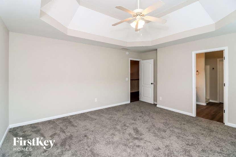 an empty living room with a ceiling fan