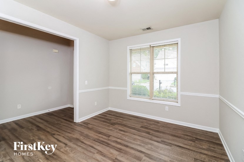 the living room of a home with wood flooring and a window