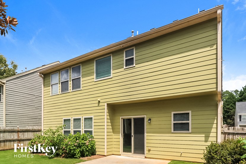 the outside of a yellow house with a yard and a driveway