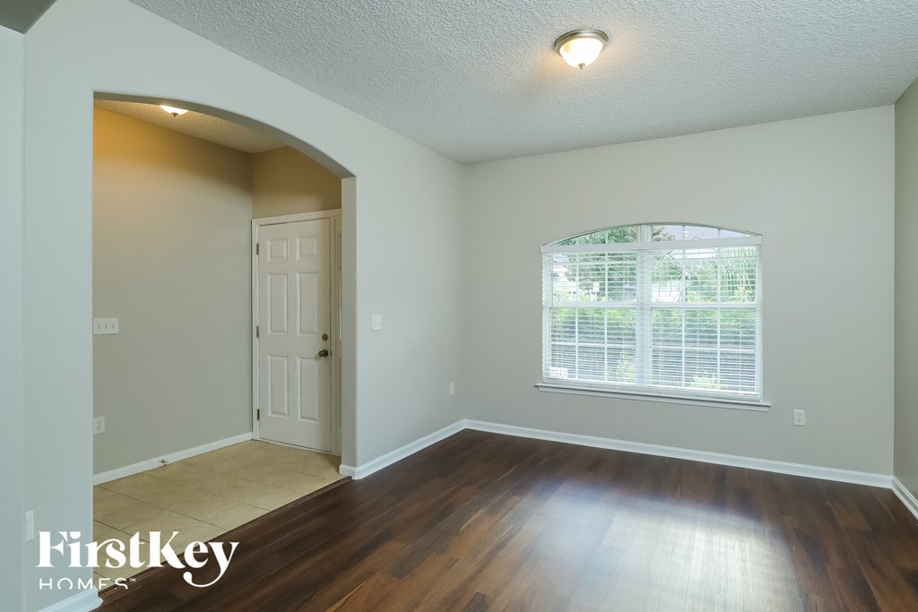 the second bedroom with hardwood flooring and a window