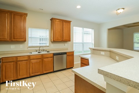 a kitchen with wooden cabinets and white counter tops and a sink