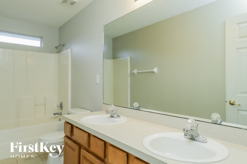 a bathroom with two sinks and a large mirror
