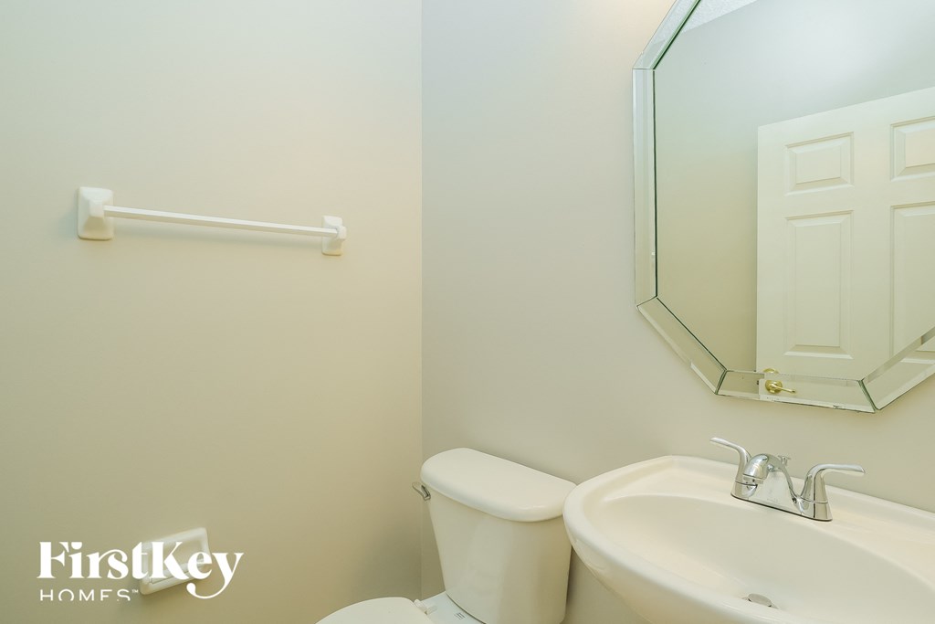a bathroom with a toilet and a sink and a mirror