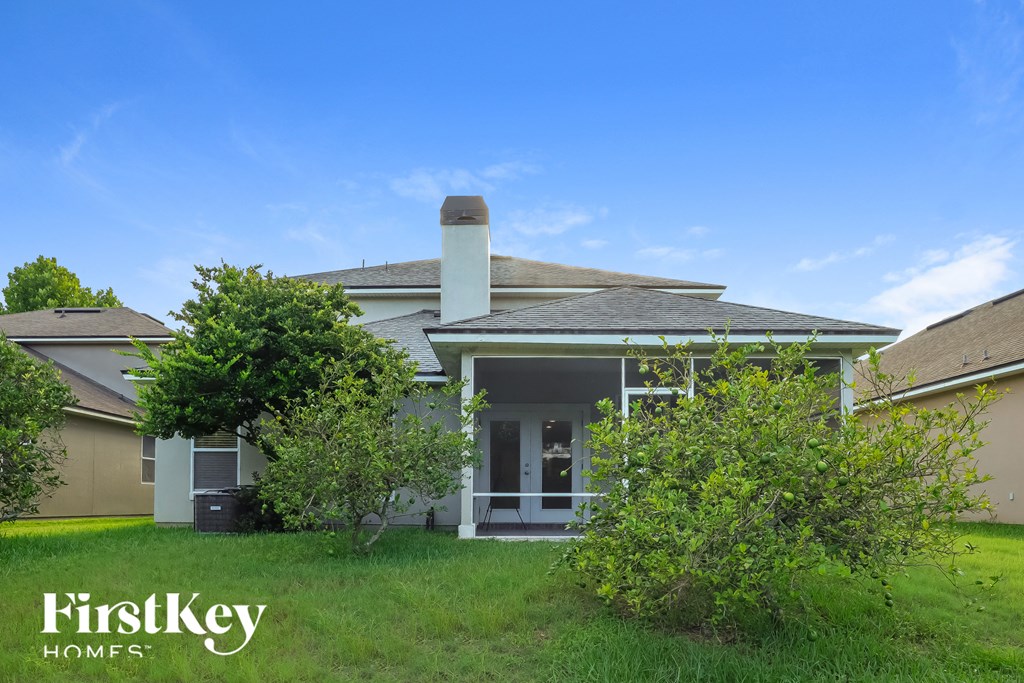 a house with a yard and trees in front of it