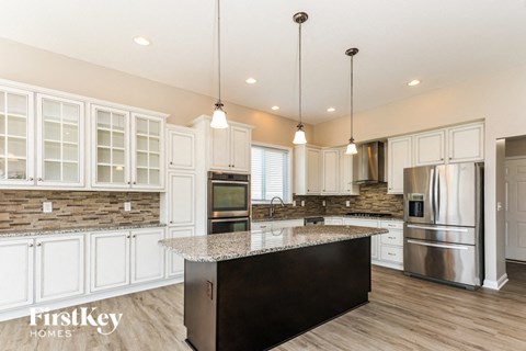 A kitchen with a granite countertop and stainless steel appliances.