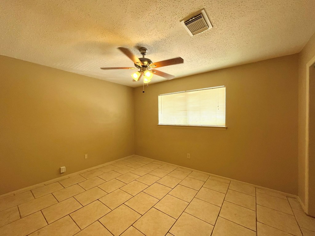 the living room has a ceiling fan and a tiled floor
