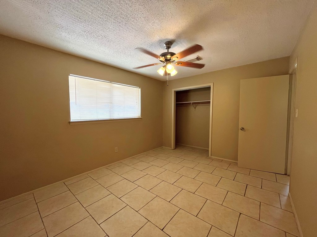 the living room of an empty house with a ceiling fan
