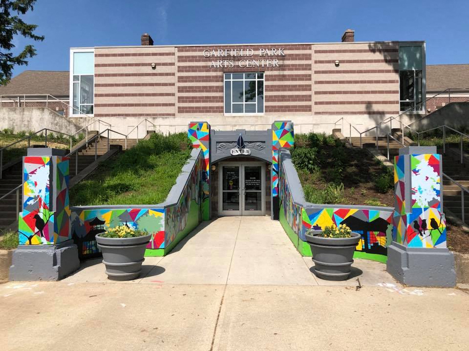 the front of a school with a building with colorful doors