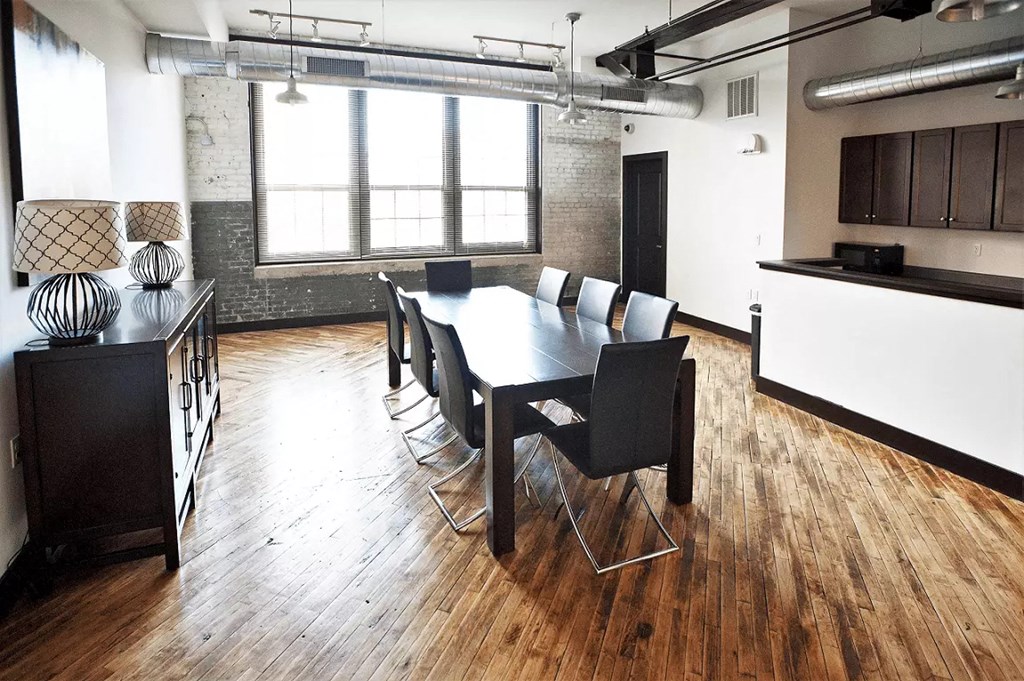 a dining room with a table and chairs in a large room