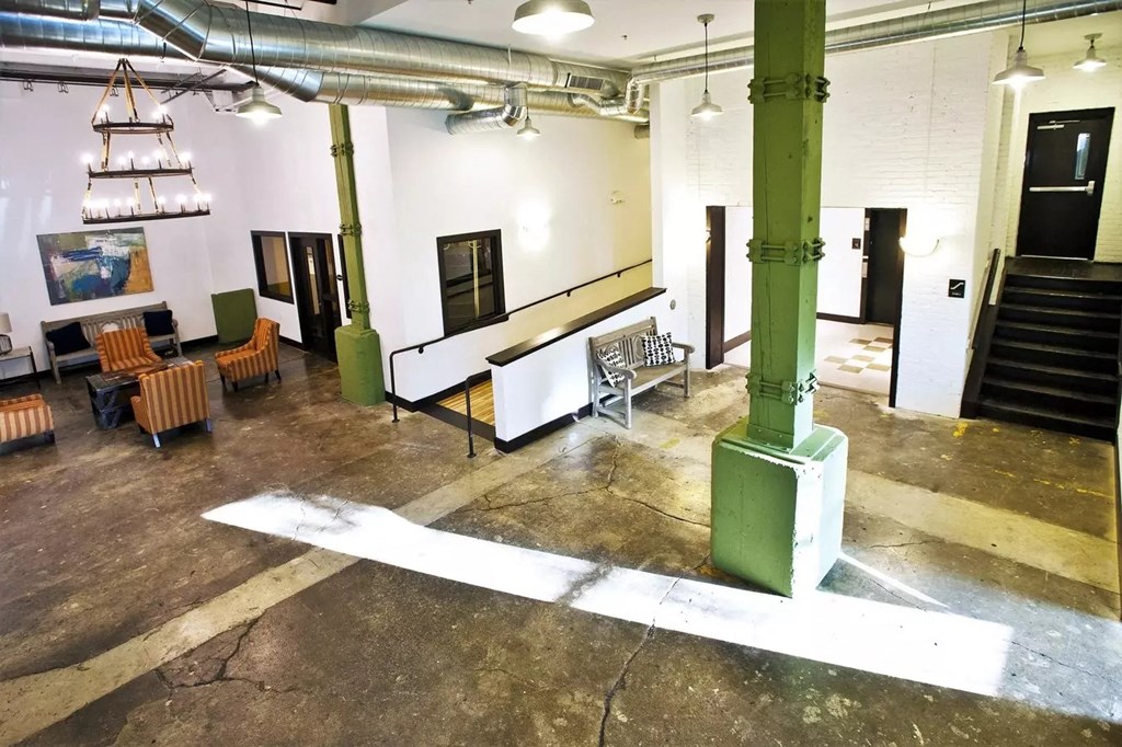a large room with tables and chairs in a room with pillars