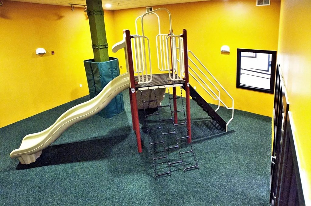 a playground with a slide and stairs in a building