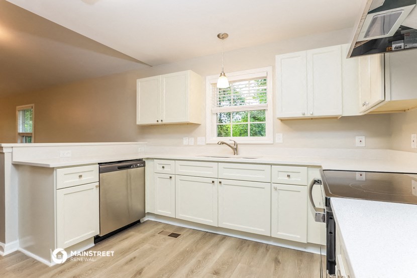 a kitchen with white cabinets and a stainless steel dishwasher