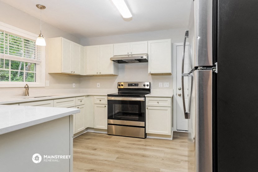 a white kitchen with stainless steel appliances and white cabinets
