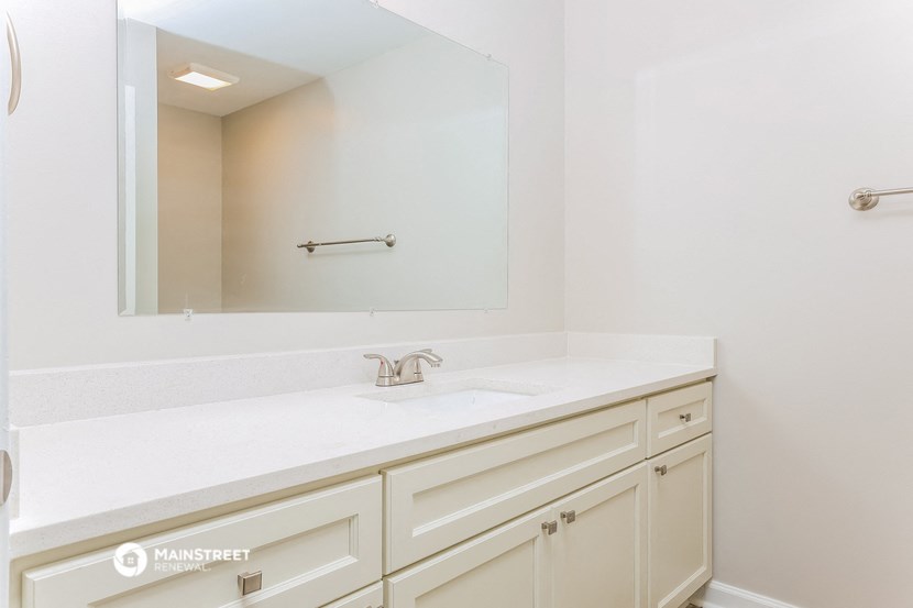 a white bathroom with a sink and a mirror