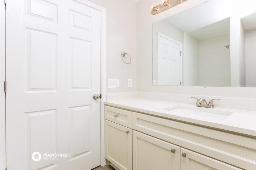 a white bathroom with a sink and a mirror
