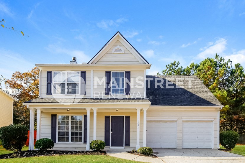 a white house with a gray roof and a black door