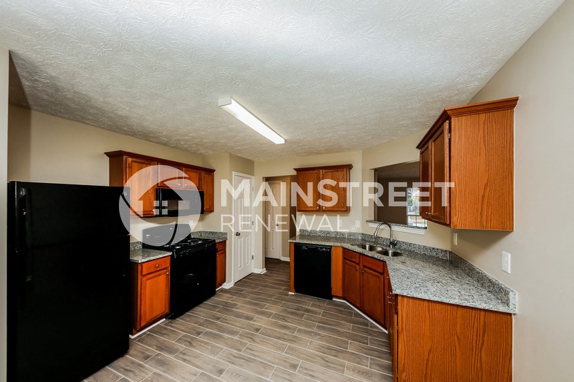 a kitchen with wood cabinets and a granite counter top