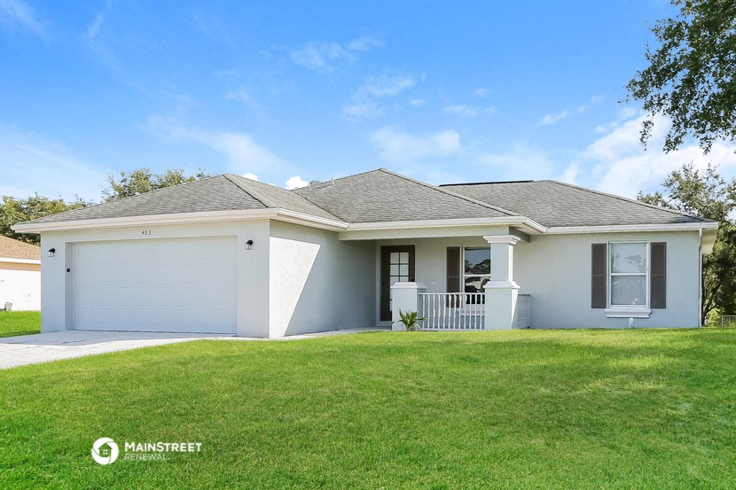 a small white house with a lawn in front of it